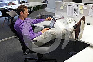 Young businessman in office with tablet - relaxed sitting position