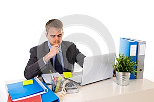 Young businessman overworked looking worried sitting at office computer desk in stress