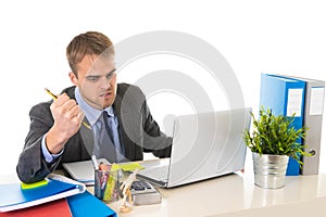 Young businessman overworked looking worried sitting at office computer desk in stress