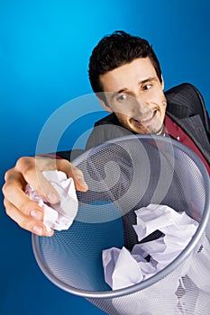 Young businessman playing baskteball with paper