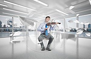 young businessman playing violin