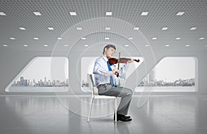 young businessman playing violin