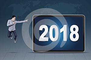 Young businessman pointing at numbers 2018