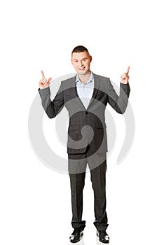 Young businessman pointing upwards