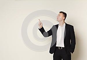 Young businessman pointing upwards with hand