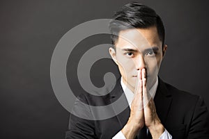 Young businessman with pray gesture