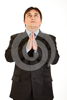 Young businessman praying for success isolated