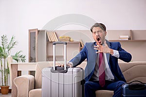 Young businessman preparing for trip at home