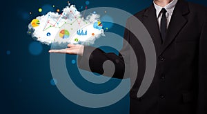 Young businessman presenting cloud with charts and graph icons a