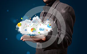 Young businessman presenting cloud with charts and graph icons a