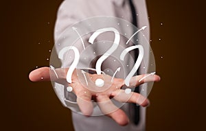 Young businessman presenting hand drawn question marks