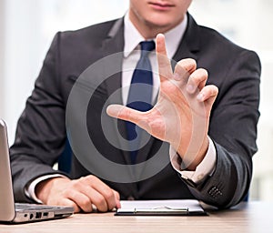 Young businessman pressing buttons in business concept