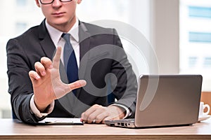 The young businessman pressing buttons in business concept