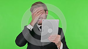 Young Businessman Reacting to Loss on Tablet on Green Background