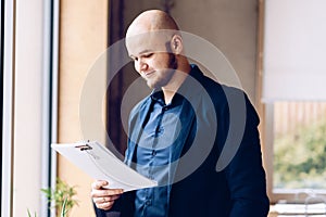 Young businessman reading documents in the office