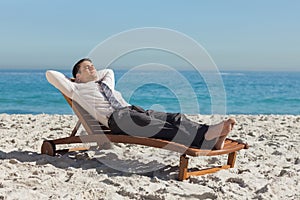 Young businessman relaxing on a deck chair