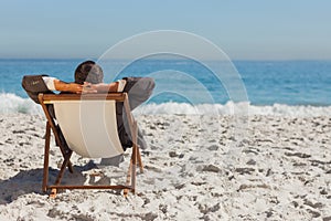 Young businessman relaxing on his sun lounger