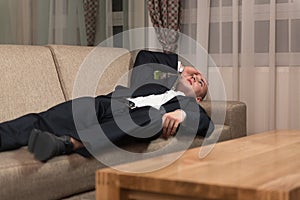 Young Businessman Resting on Sofa at Home