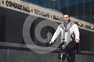 Young businessman riding bicycle on urban street