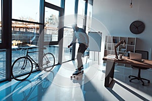 young businessman riding longboard