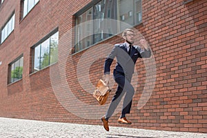 Young businessman running in a city street