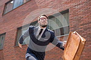 Young businessman running in a city street