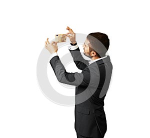 Young businessman scrutinizing banknote