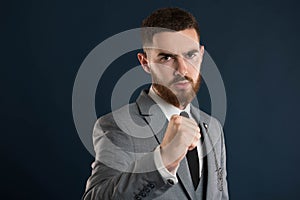 Young businessman showing his fist aggressively