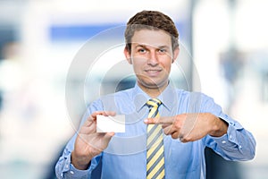 Young businessman shows his business card