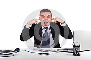 Young businessman shuts his ears with his hands and screaming isolated on white background