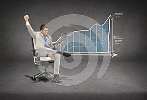 Young businessman sitting in chair with laptop