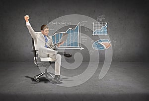 Young businessman sitting in chair with laptop