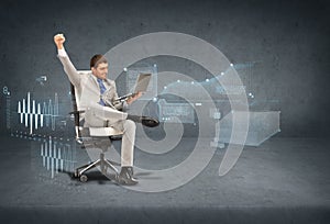 Young businessman sitting in chair with laptop