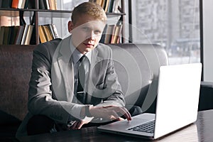 Young businessman sitting at desk with laptop