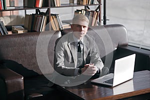 Young businessman sitting at desk with laptop