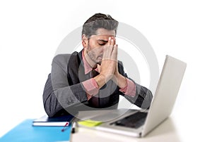 Young businessman sitting at office desk working on computer laptop desperate worried in work stress