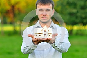 Young businessman with a small house