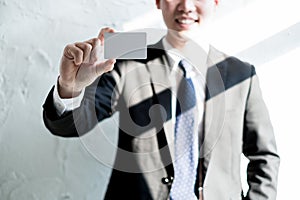 Young businessman smile and holding blank business card in office, business concept