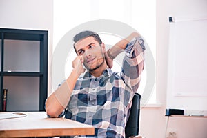 Young businessman speaking on the phone in office