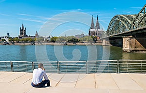 young businessman spending his time at the deutzer rhine boulevard in Cologne at summer