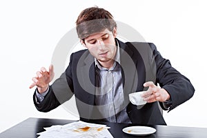 Young businessman spills coffee for documents