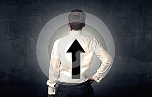 Young businessman standing with arrow on his back