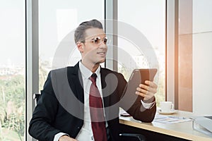 Young businessman is stting in the office while using tablet