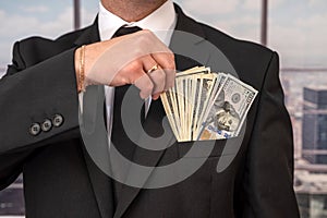 young businessman in a stylish jacket from a suit with a large sum of dollars.