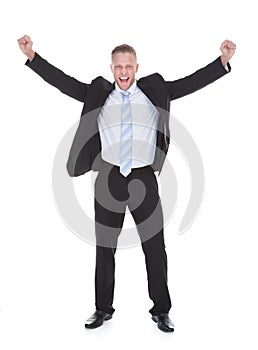 Young businessman in a suit standing cheering