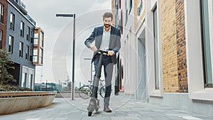 Young Businessman in a Suit Starts to Riding on an Electric Scooter. Modern Entrepreneur Uses Cont