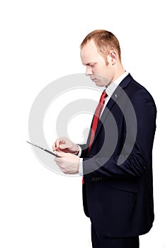 Young businessman in a suit working on a tablet computer on an i