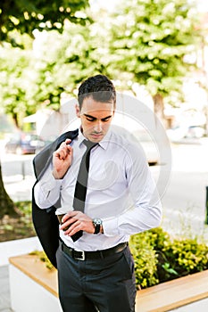 Young businessman take break to drink coffee but now looking how time is it