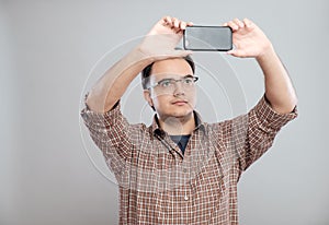 Young businessman taking photos with mobile phone