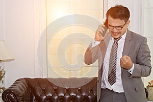 Young businessman talking on cell phone at office successfully w